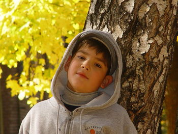 Close-up of boy on tree trunk