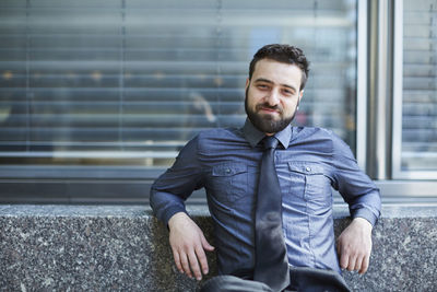 Portrait of a smiling young man sitting outdoors