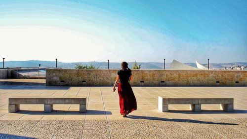 Rear view of woman standing against sky