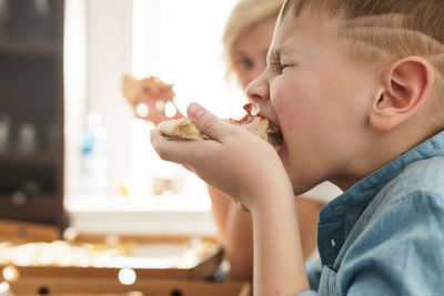 Close-up of boy eating food at home