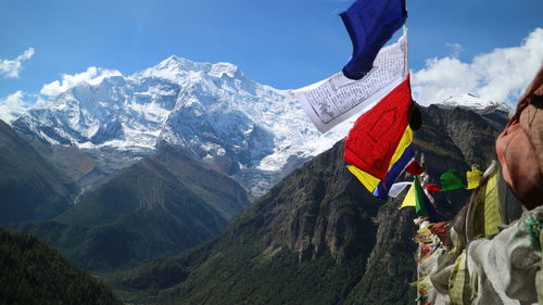 Panoramic view of mountains and flags against sky