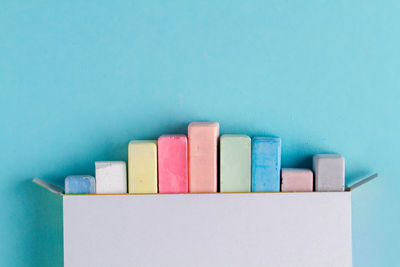 Close-up of multi colored pencils on table against blue background