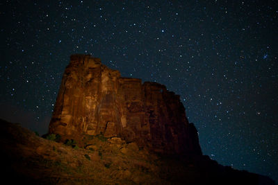 Low angle view of rock formation against sky at night