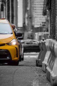 Yellow car on street against buildings