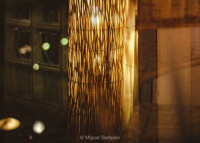 Close-up of illuminated lighting equipment on window at night