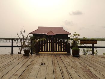 Pier amidst lake against sky during sunset