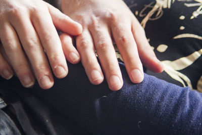 Cropped image of hand touching baby