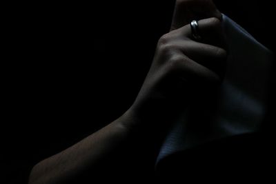 Close-up of human hand against black background