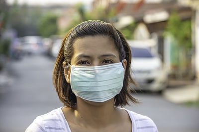 Portrait of woman in protective mask standing outdoors