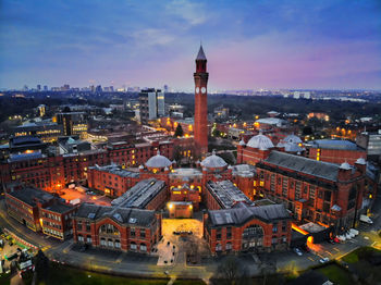 High angle view of illuminated buildings in city against sky during sunset