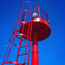 Low angle view of red tower against clear blue sky