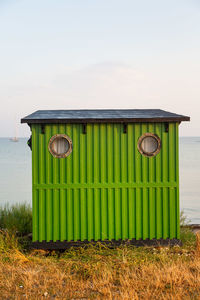 Lifeguard hut on field against sky