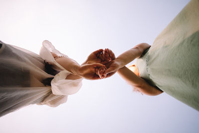 Low angle view of lesbian couple holding hands