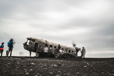 Abandoned airplane on land against sky