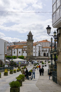 People walking on street amidst buildings in city