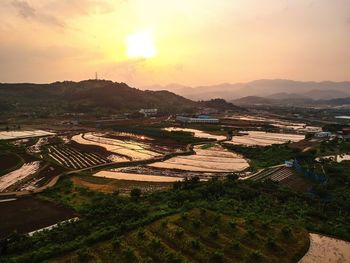 High angle view of agricultural field against sky during sunset