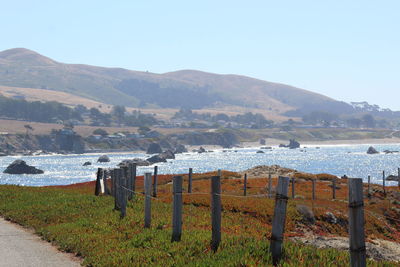 Scenic view of sea and mountains against clear sky