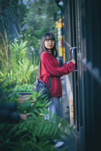 Asian teenager standing against close door