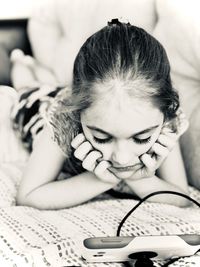 Girl looking at smart phone while lying on sofa at home