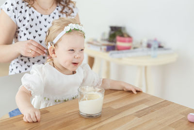 High angle view of cute baby girl sitting on table