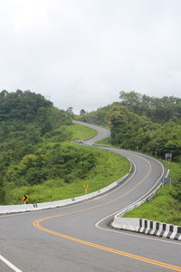 High angle view of vehicles on road by trees against sky