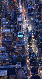 High angle view of illuminated street amidst buildings in city