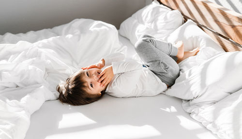 High angle view of boy lying down on floor at home