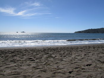 Scenic view of beach against blue sky