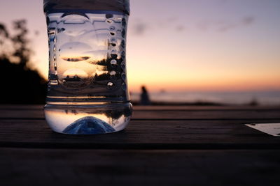Close-up of water on table against sky during sunset