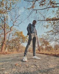 Man standing by tree against sky