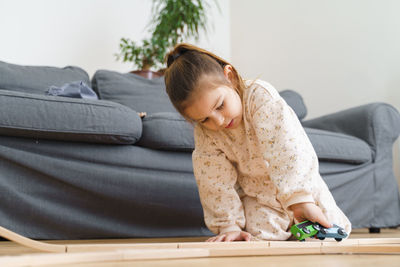 Cute girl playing with toy at home