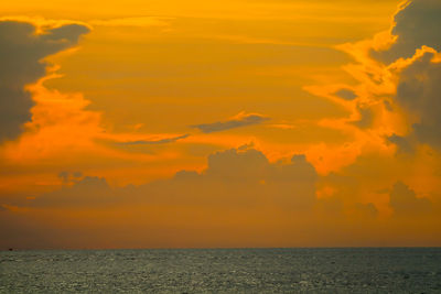 Scenic view of sea against dramatic sky during sunset