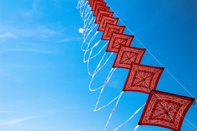 Low angle view of communications tower against blue sky