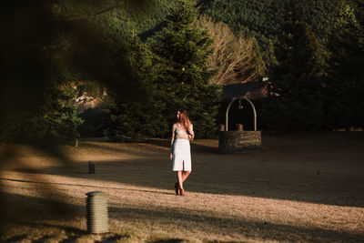 Full length rear view of woman walking on street