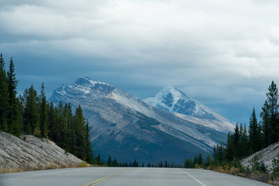 Road amidst snowcapped mountains against sky