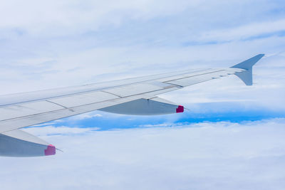 Cropped image of aircraft wing flying in sky