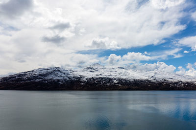 Snow covered mountains against cloudy sky