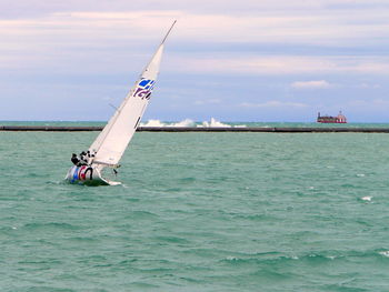 Sailboat sailing on sea against sky