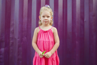 Portrait of girl standing against yellow wall