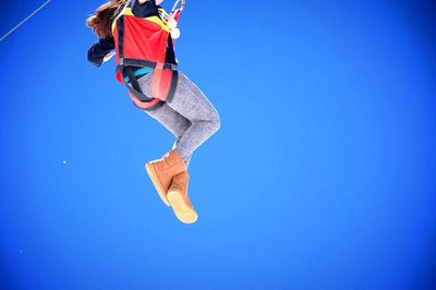 Low angle view of person skylining against clear blue sky