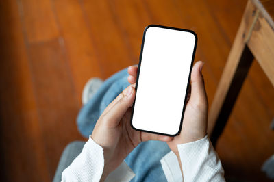 Midsection of woman using mobile phone on table