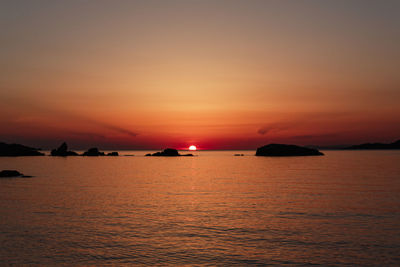 Scenic view of sea against romantic sky at sunset