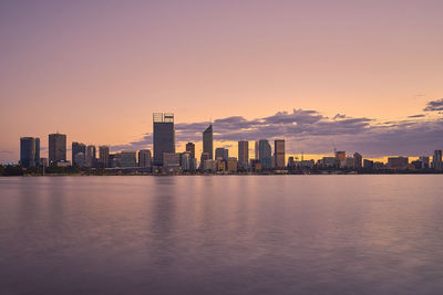 View of city at waterfront during sunset