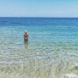 Man swimming in sea against sky