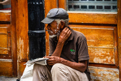 Full length of man sitting outdoors