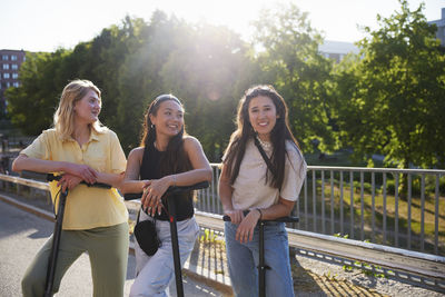 Young female friends standing together and looking at camera