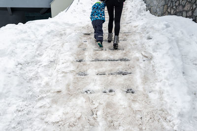 Low section of person walking on snow