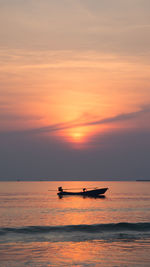 Silhouette boat in sea against sky during sunset