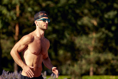 Portrait of shirtless boy standing outdoors