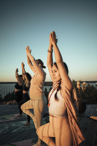 Women with hands clasped exercising on patio at retreat center